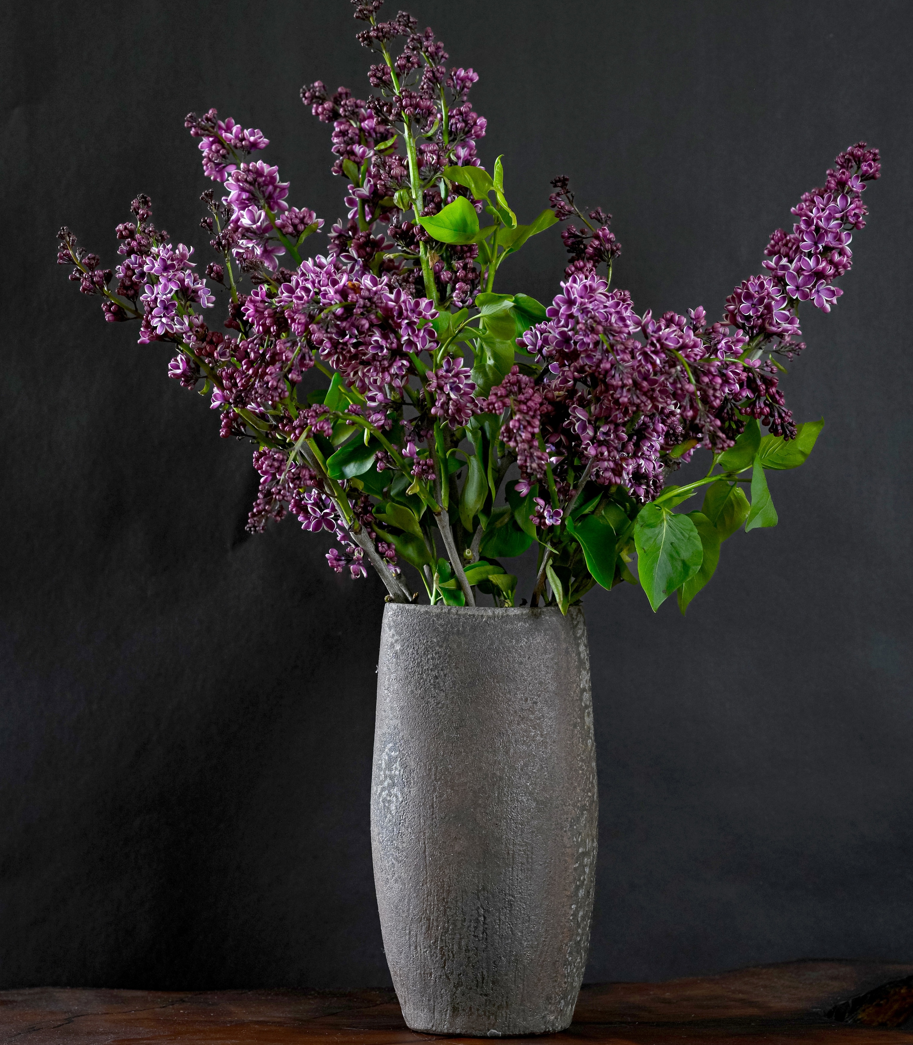 Dark oval vase with lilacs